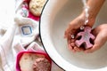 ChildÃ¢â¬â¢s hands under white bowl with water upon water stream Royalty Free Stock Photo